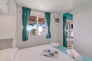 A hotel room with a bed, a window with curtains, a view of the outdoors, and a door leading to a balcony. - Sea View - 40 Parallelo - Superior 8, Marina di Camerota, Italy (Marina di Camerota)