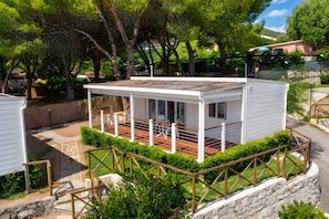 A small, single-story house with a covered patio and a stone retaining wall. - Sea View - 40 Parallelo - Superior 8, Marina di Camerota, Italy (Marina di Camerota)