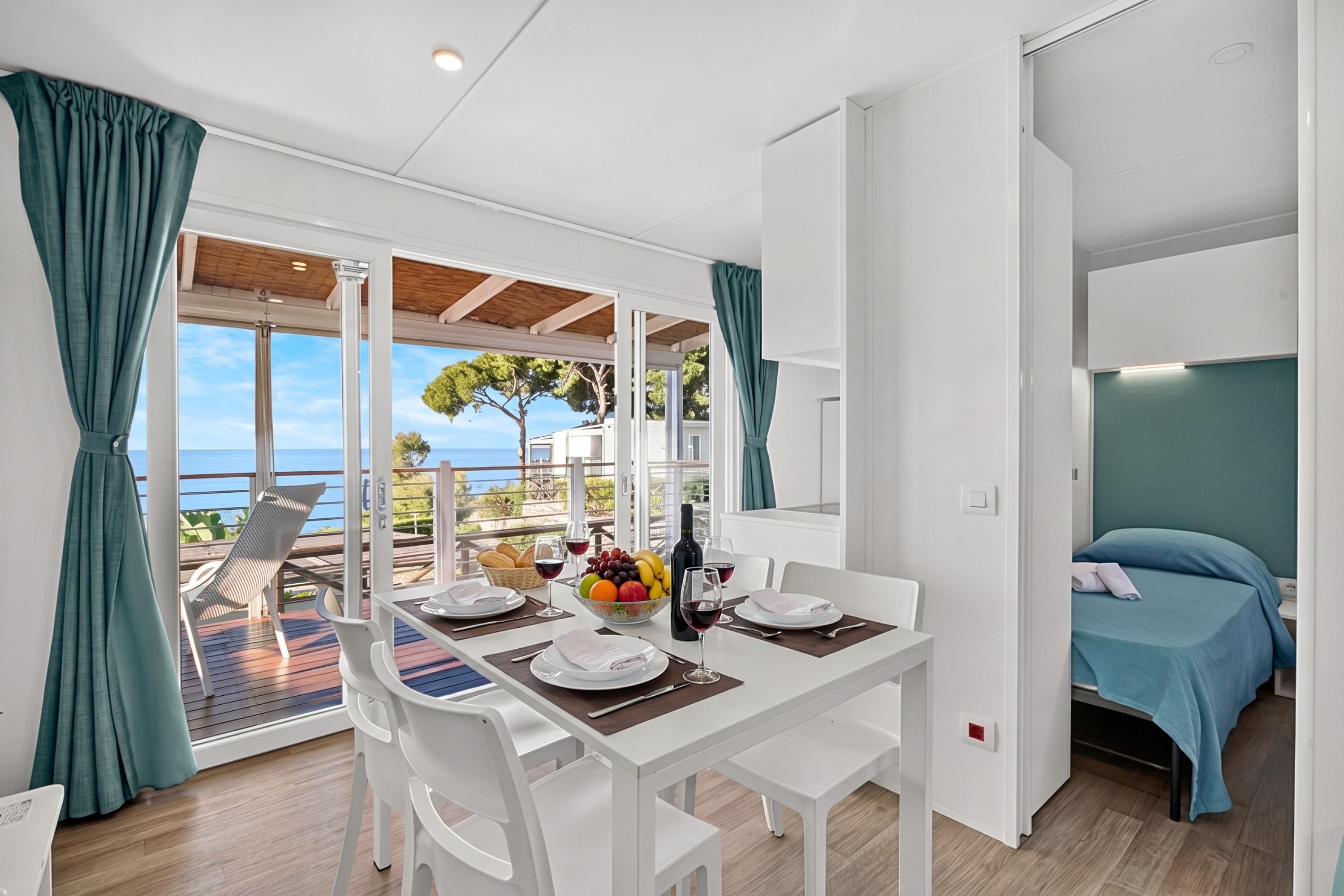 Une chambre moderne avec un coin repas, un lit et une vue sur la mer.