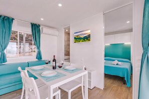 Ein modernes Zimmer mit Essbereich, einem Bett und einem Bild an der Wand.