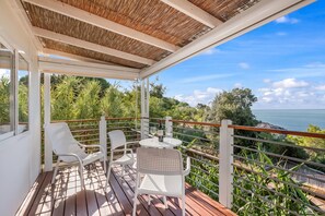 A covered outdoor seating area with a table and chairs, overlooking a scenic landscape. - Sea View - 40 Parallelo - Deluxe 5, Marina di Camerota, Italy (Marina di Camerota)
