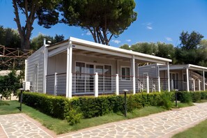 Una casa mòbil moderna d'una sola planta amb un porxo cobert i un pati tancat per una tanca.