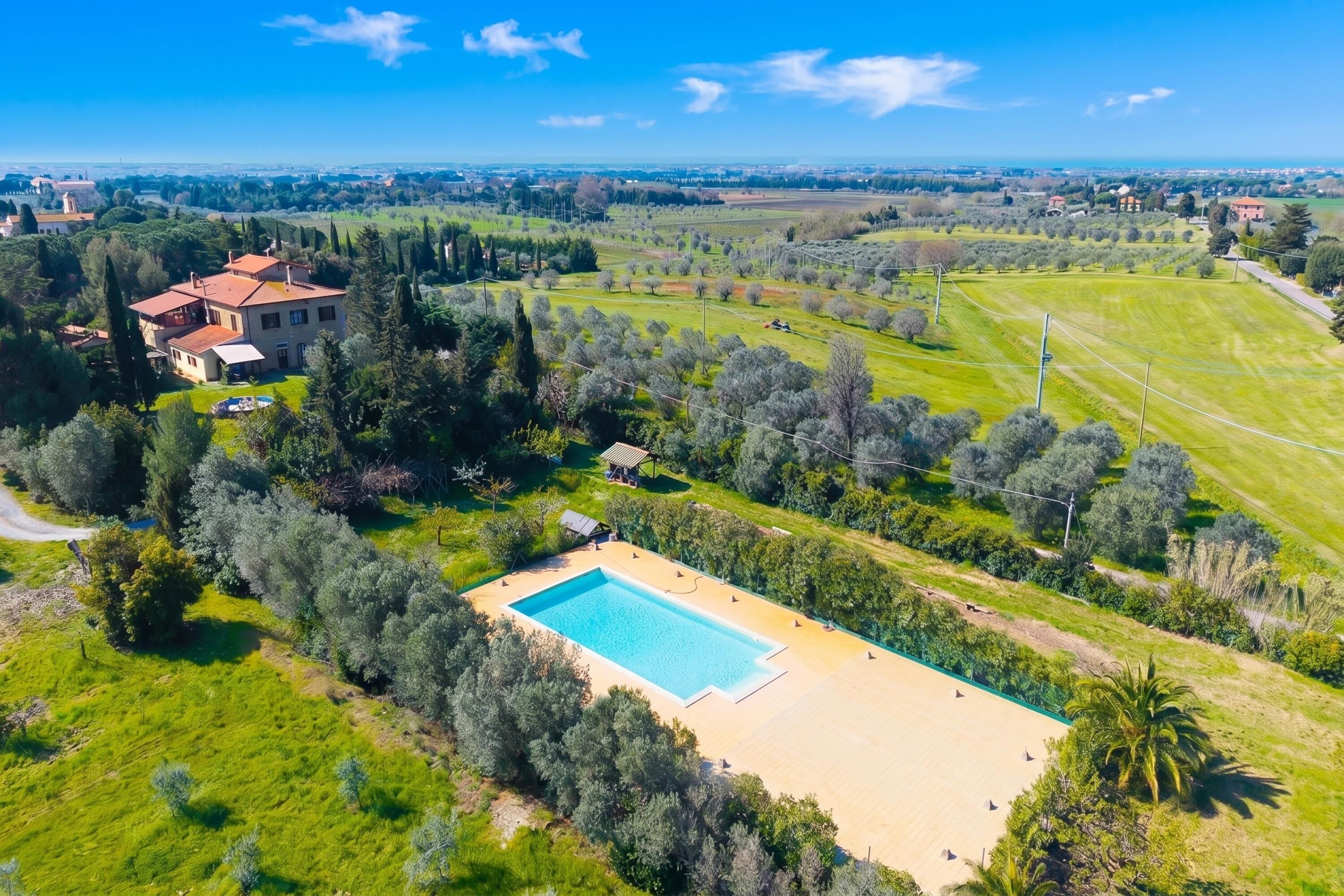 Una propiedad amplia con piscina, rodeada de exuberante vegetación y vistas al campo.