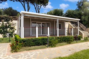 A modern building with a covered porch, a staircase, and a garden with hedges and flowers. - Sea View - 40 Parallelo - Deluxe 1, Marina di Camerota, Italy (Marina di Camerota)