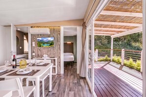 A modern interior with a dining area, a TV mounted on a wall, and a balcony with a view of greenery. - Sea View - 40 Parallelo - Deluxe 1, Marina di Camerota, Italy (Marina di Camerota)