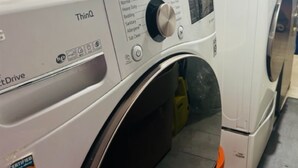 Lavadora de carga frontal con panel de control, etiqueta de certificación e indicación de modelo ThinQ.