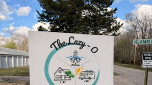 A sign for The Lazy-O Resort with icons for marina, stay, park, and a boat.
