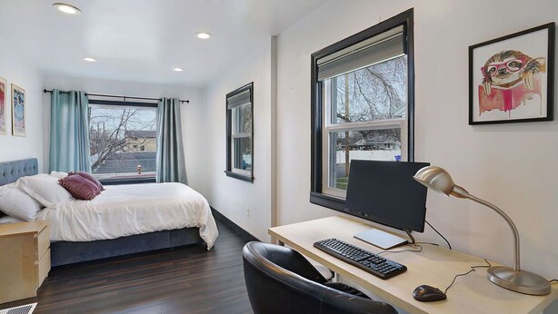 A modern hotel room with a bed, desk, computer, and large windows. - Private patio, close to downtown & all major ski resorts (South Salt Lake)