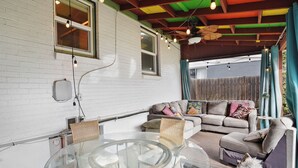 A covered patio with a glass table, wicker chairs, a sofa, and a ceiling fan. - Private patio, close to downtown & all major ski resorts (South Salt Lake)