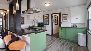 A modern kitchen with a central island, green cabinets, and a white tiled backsplash. - Private patio, close to downtown & all major ski resorts (South Salt Lake)