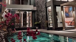 A modern hotel with a glass infinity pool, a marble wall, and a large window. - Regal Riverside Villas (Da Nang)