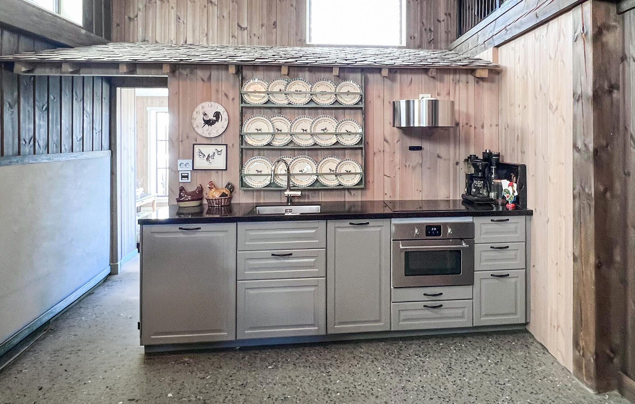 Una cucina con pareti in legno, un'isola centrale con lavello e una macchina da caffè.