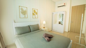 A hotel room with a bed, a nightstand with a lamp, a wardrobe, and two framed leaf artworks on the wall. - Legasi Kampung Baru By Skylivia (Kuala Lumpur)