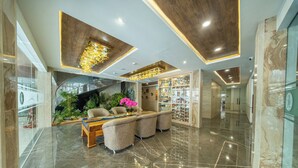 A lobby with a marble floor, seating area, and a display of items. - Horison IJ Kudus (Kudus)