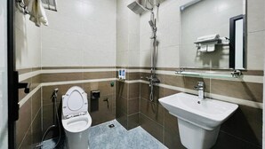 Une salle de bain moderne équipée de toilettes, d’un bidet et d’un lavabo.