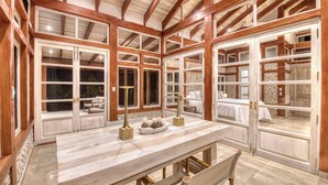 A spacious room with a large wooden-framed window, a marble-topped table, and a bench. - Villa 4 - The Ledge - Infinity Pool Overlooking the Ocean & Mountains (Chinampas)