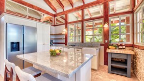 A kitchen with a central island, stainless steel appliances, and a view of greenery outside. - Villa 4 - The Ledge - Infinity Pool Overlooking the Ocean & Mountains (Chinampas)