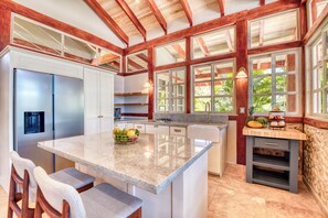 A kitchen with a central island, stainless steel appliances, and a view of greenery outside. - Villa 4 - The Ledge - Infinity Pool Overlooking the Ocean & Mountains (Chinampas)