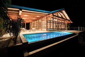 A modern house with a swimming pool, wooden deck, and large windows. - The Ledge - Infinity Pool Overlooking the Ocean & Mountains (Chinampas)