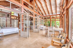 A spacious interior with a high ceiling, large windows, and a central dining area. - The Ledge - Infinity Pool Overlooking the Ocean & Mountains (Chinampas)