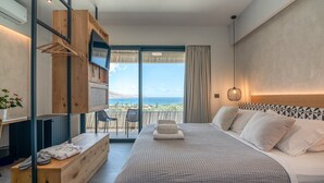 A bedroom with a large bed, a wooden bench, a TV, and a balcony with a view. - Nusa Retreat - Seaview luxury residences - ideal for groups  (Kissamos)