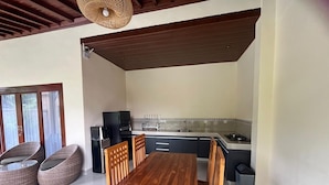 Eine Küche mit Esstisch und Stühlen, einem Kühlschrank und einem Herd.