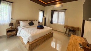 Ein Schlafzimmer mit einem hölzernen Bett, Nachttischen, einem Schreibtisch und einem Stuhl.