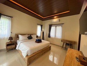 Ein Schlafzimmer mit einem hölzernen Bett, Nachttischen, einem Schreibtisch und einem Stuhl.