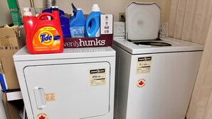 Zwei Waschmaschinen mit Frontlader und ENERGY GUIDE-Aufklebern, eine rote Tide Waschmittelflasche und eine Packung 7up.