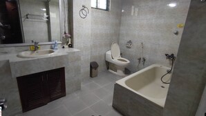 Un baño con lavamanos, inodoro y bañera.