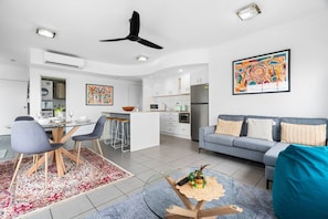 A modern living space with a dining area, kitchen, and seating area. - Zen Bayline Villa: bayview - balcony - rooftop (Darwin City)