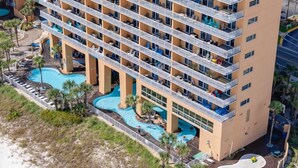 Un hôtel à plusieurs étages doté de balcons, d’un espace piscine et offrant une vue sur la plage.