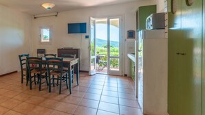 Una cocina con comedor, televisor y vistas al exterior.