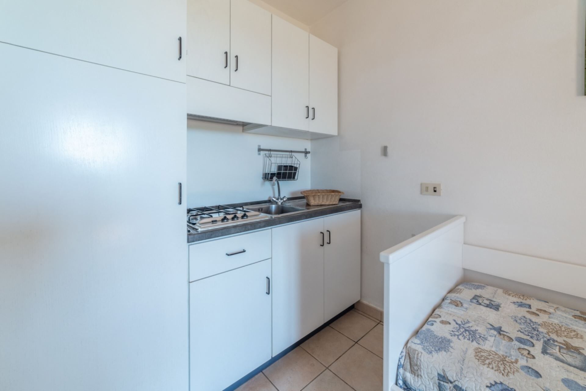 Una pequeña cocina americana con estufa a gas, lavabo y armarios.