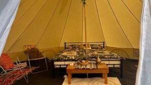 Ein Zelt mit einem Bett, einem Tisch und einem Stuhl.