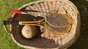 Ein Korankorb mit einer Tennisschläger, einem Ball und einem Netz.