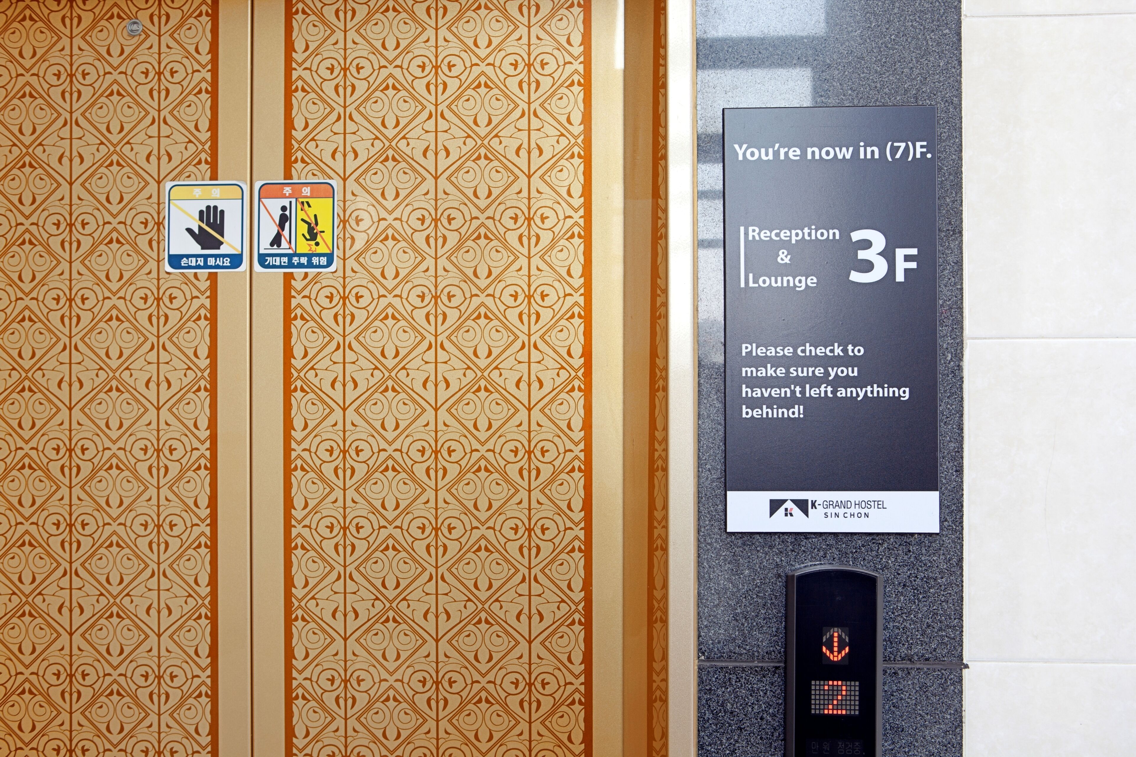 Interior de un ascensor con paredes decoradas, un cartel que indica el nivel 3F y una pantalla digital.
