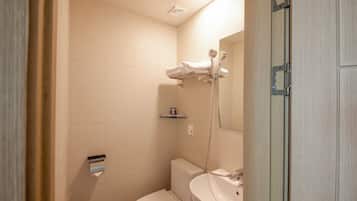 A bathroom with a toilet, sink, and shower.