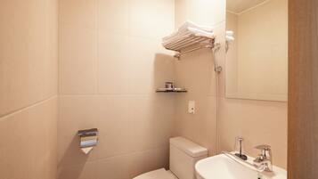 A bathroom with a toilet, sink, towel rack, and shower.