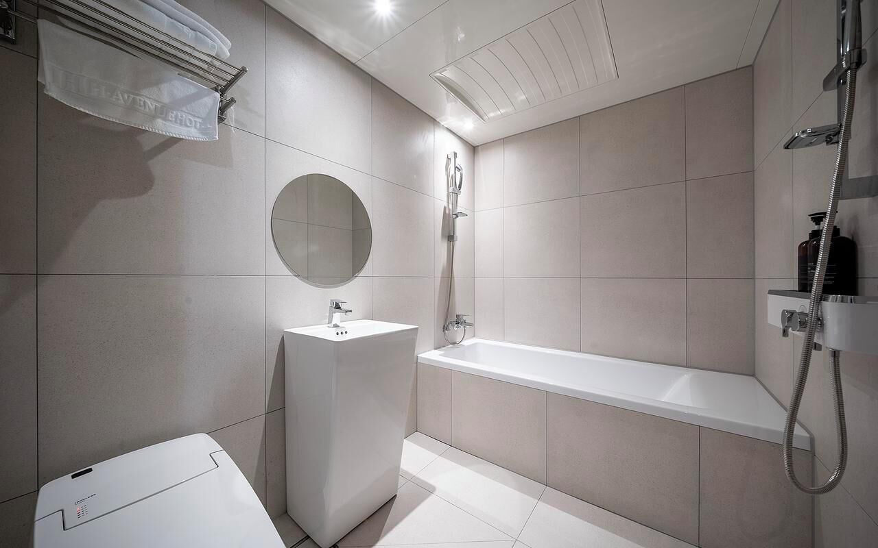 A modern bathroom with a sink, mirror, and shower.