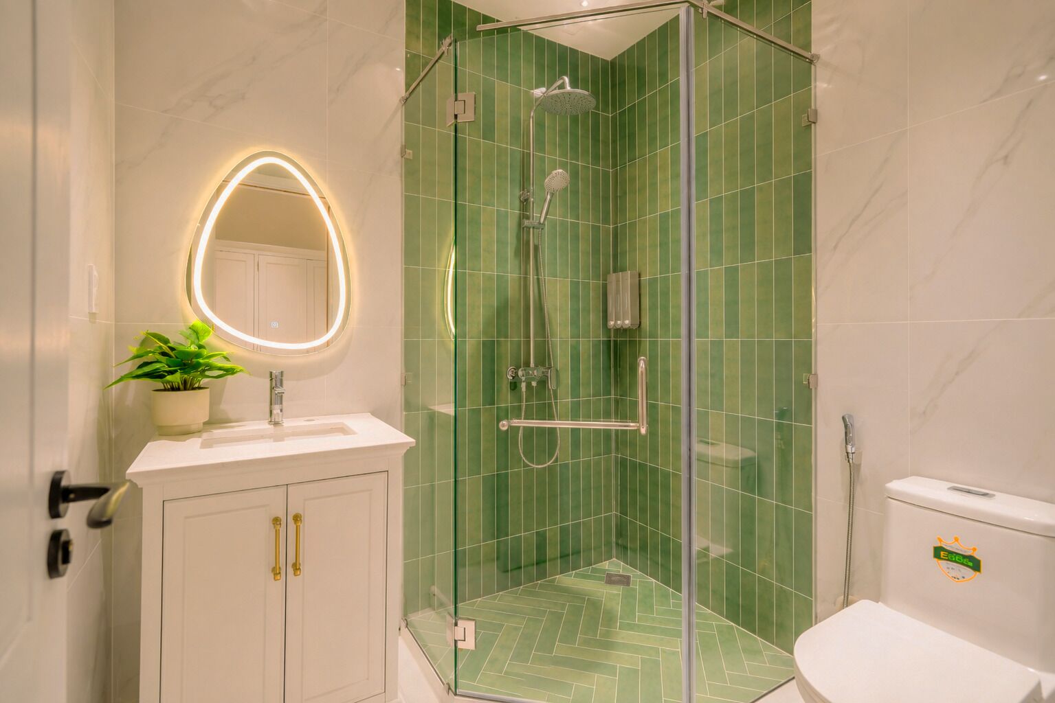 A bathroom with a glass-enclosed shower, a white sink with a mirror, and a toilet.