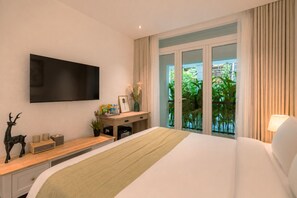 A hotel room with a bed, a desk, a television, and a balcony with plants. - Amana Boutique Hotel - Tran Quoc Thao (Ho Chi Minh City)