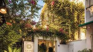 A boutique hotel entrance with a white facade, a sign reading 'AMANA BOUTIQUE,' and a covered entrance area with potted plants. - Amana Boutique Hotel - Tran Quoc Thao (Ho Chi Minh City)
