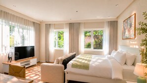 A modern hotel room with a large bed, a television, a sofa, and a desk. - Amana Boutique Hotel - Tran Quoc Thao (Ho Chi Minh City)