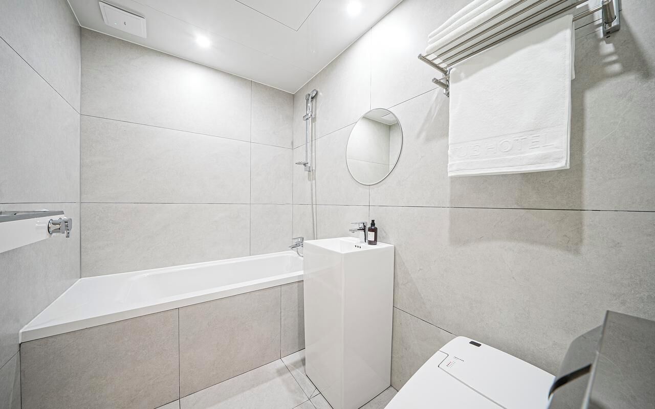 A modern bathroom with a bathtub, a sink, and a mirror.