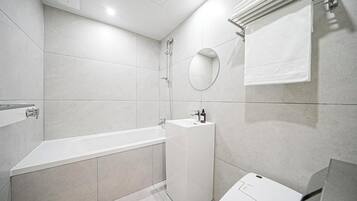 A modern bathroom with a bathtub, a sink, and a mirror.