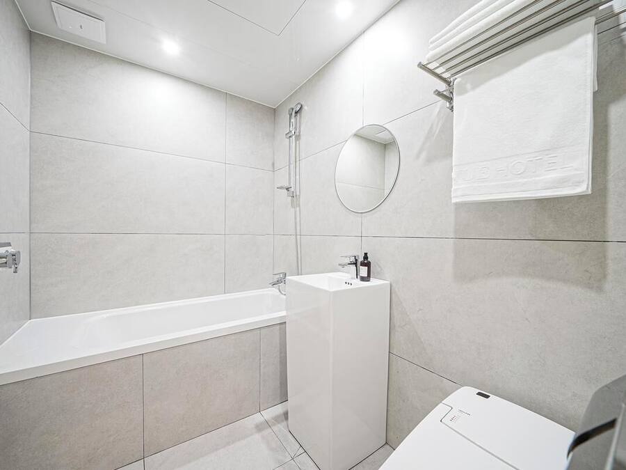 A modern bathroom with a bathtub, a sink, and a mirror.