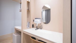 A modern bathroom with a white countertop, a hairdryer, a mirror, and a wooden vanity. - Daegu Dongdaegu Station H Avenue Dongdaegu Station Branch (Daegu)