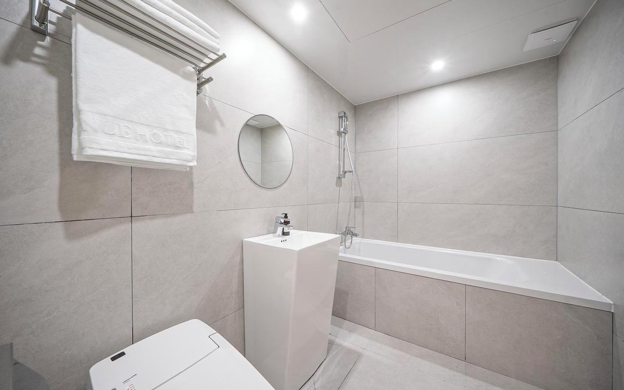 Un baño moderno con bañera, lavamanos y perchero.