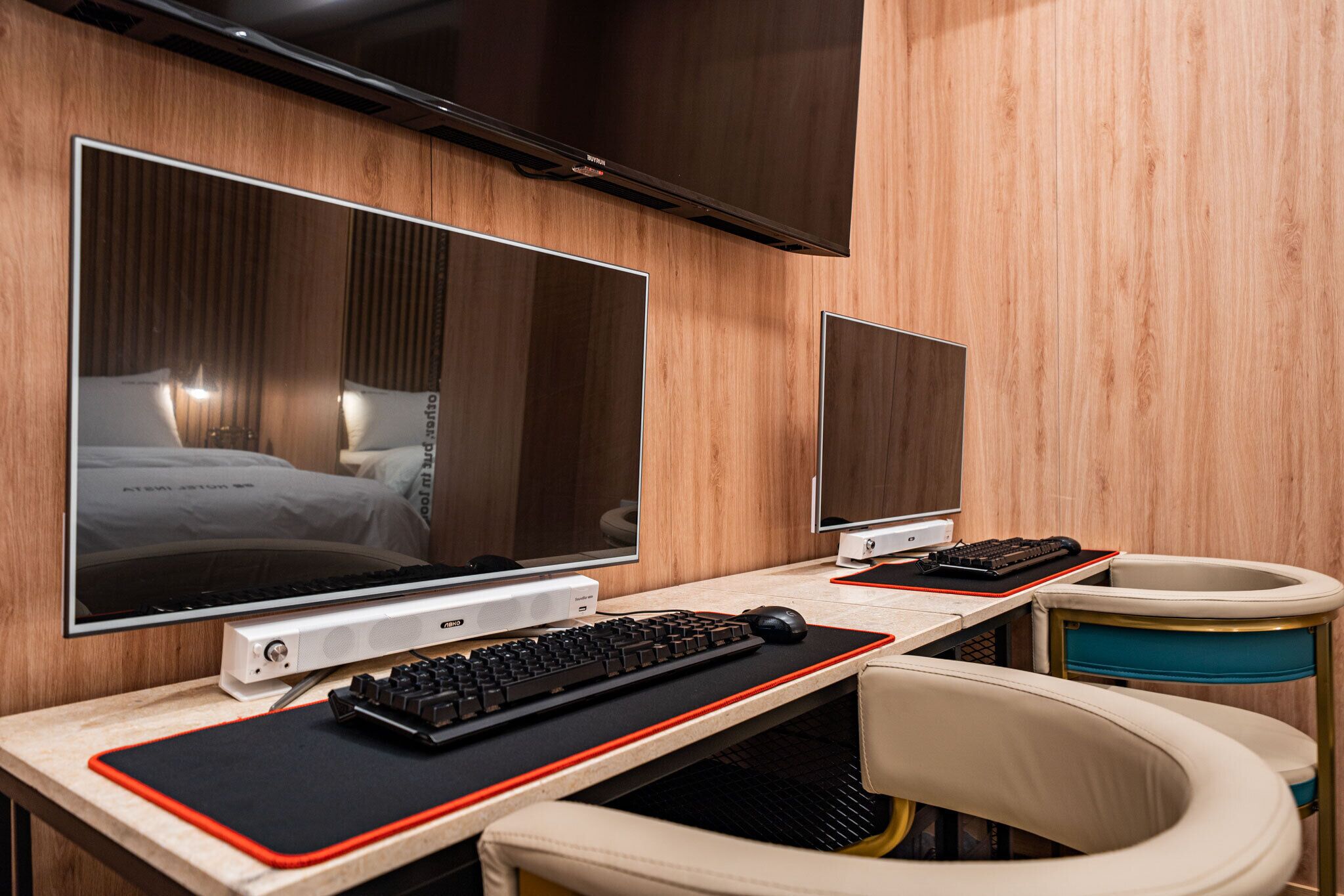 Quarto de hotel com uma cama grande, uma escrivaninha com computador e uma televisão.